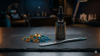 A clinical setup featuring premium hard wax beads, a metallic application spatula, and a biomimetic skin serum on a dark slate surface.